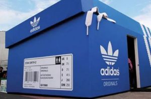 Pop up store e-commerce: loja da Adidas em formato de caixa de sapato com elementos da Cultura Organizacional (cores, logos, símbolos, etc.)