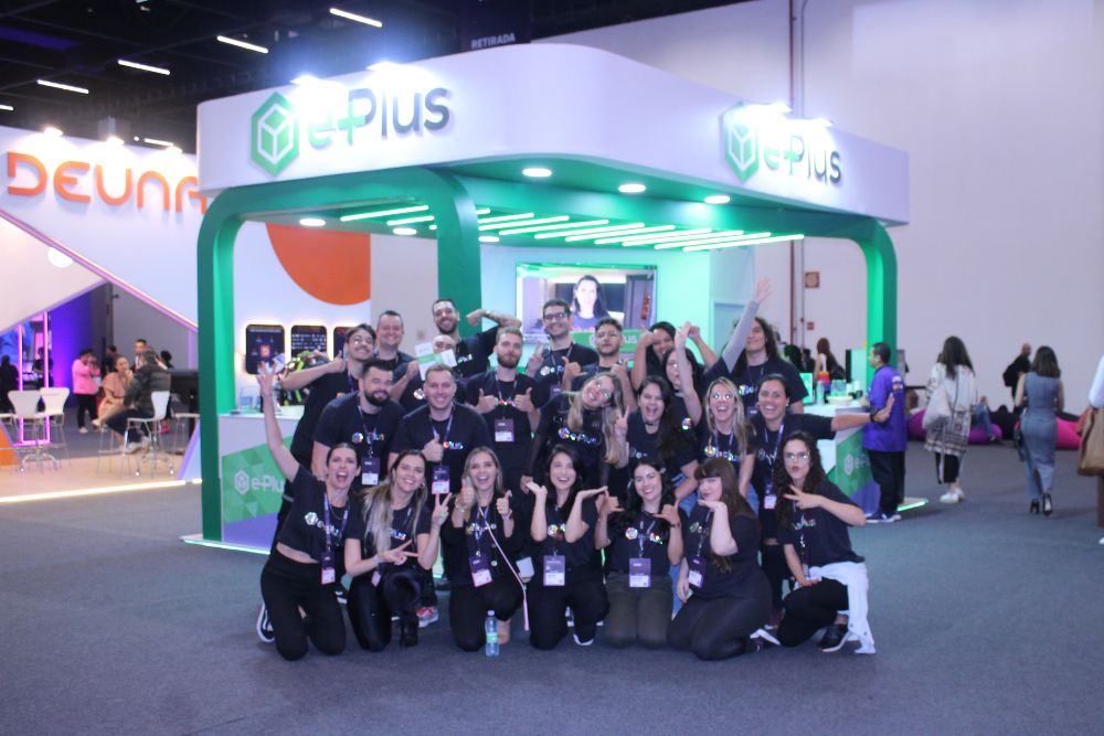 vtex day Equipe da agência e-Plus em frente ao stand do VTEX Day 2024