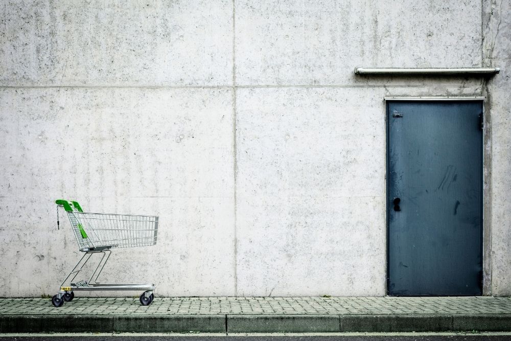 carrinho abandonado Carrinho de supermercado vazio e abandonado em uma calçada, simbolizando o carrinho abandonado no e-commerce.